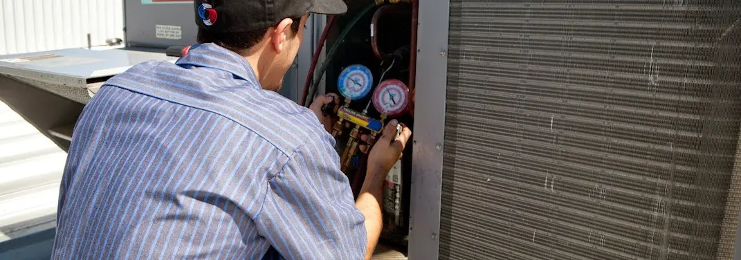 HVAC technician servicing a condenser unit in Bethlehem